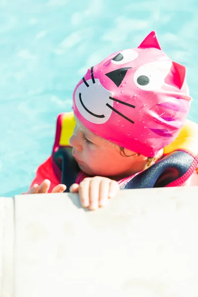 小さな女の子がベストを泳ぎ 屋外プールで泳いでカップを泳ぐ — ストック写真