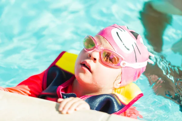 小さな女の子がベストを泳ぎ 屋外プールで泳いでカップを泳ぐ — ストック写真