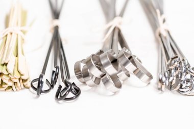 Çelik ve ahşap şişleri bir beyaz tahta arka plan boyalı.