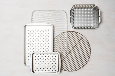 Barbekü çeşitli ızgara beyaz boyalı ahşap zemin üzerinde tepsiler.