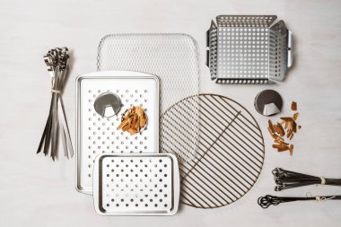 Barbekü çeşitli ızgara beyaz boyalı ahşap zemin üzerinde tepsiler.