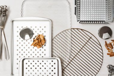 Barbekü çeşitli ızgara beyaz boyalı ahşap zemin üzerinde tepsiler.