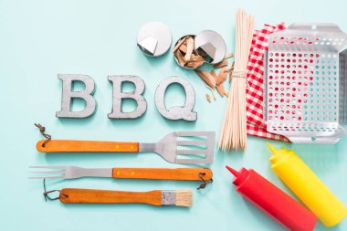 Araçlar mavi arka plan üzerinde ızgara ile barbekü işareti metal.