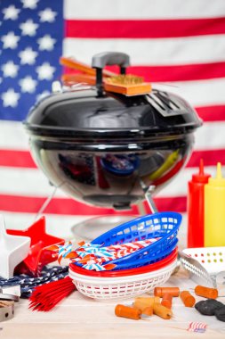 Küçük yuvarlak kömür ızgara ve 4 Temmuz süslemeleri Amerikan üzerinde arka plan bayrak.