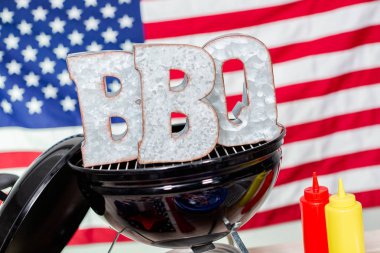 Küçük yuvarlak kömür ızgara ile 4 Temmuz barbekü işareti metal dekorasyon.
