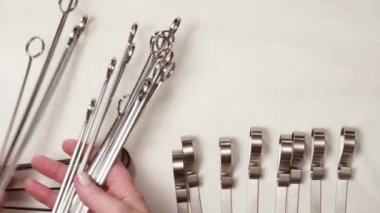 Çelik ve ahşap şişleri bir beyaz tahta arka plan boyalı.