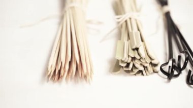 Çelik ve ahşap şişleri bir beyaz tahta arka plan boyalı.