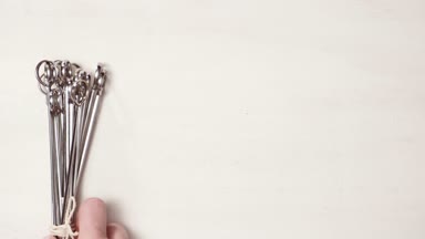 Çelik ve ahşap şişleri bir beyaz tahta arka plan boyalı.