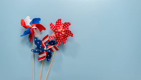 July 4th theme paper pinwheels on blue background.