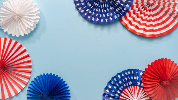 July 4th theme paper fans on blue background.