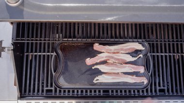 Dökme demir zor durumda açık gaz ızgara içinde pastırma kızartma.