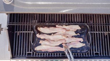 Dökme demir zor durumda açık gaz ızgara içinde pastırma kızartma.