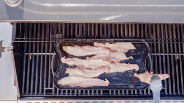 Dökme demir zor durumda açık gaz ızgara içinde pastırma kızartma.