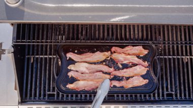 Dökme demir zor durumda açık gaz ızgara içinde pastırma kızartma.