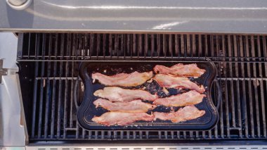 Dökme demir zor durumda açık gaz ızgara içinde pastırma kızartma.