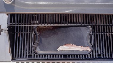 Dökme demir zor durumda açık gaz ızgara içinde pastırma kızartma.