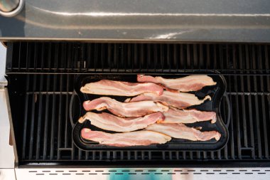 Dökme demir zor durumda açık gaz ızgara içinde pastırma kızartma.