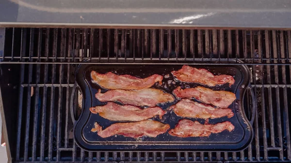 Dökme demir zor durumda açık gaz ızgara içinde pastırma kızartma.
