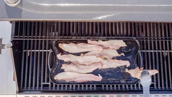 Dökme demir zor durumda açık gaz ızgara içinde pastırma kızartma.