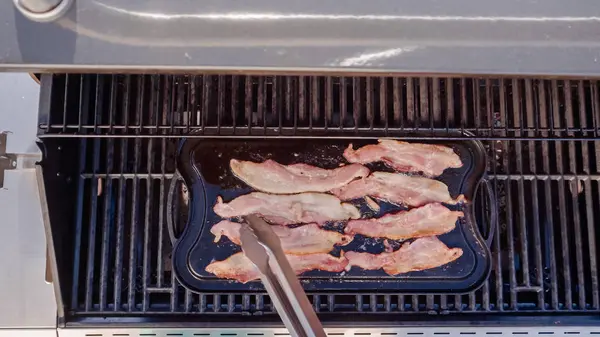 Dökme demir zor durumda açık gaz ızgara içinde pastırma kızartma.