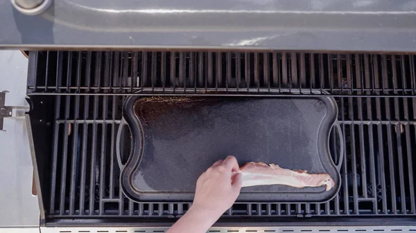 Dökme demir zor durumda açık gaz ızgara içinde pastırma kızartma.