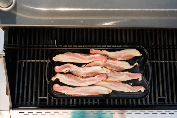 Dökme demir zor durumda açık gaz ızgara içinde pastırma kızartma.