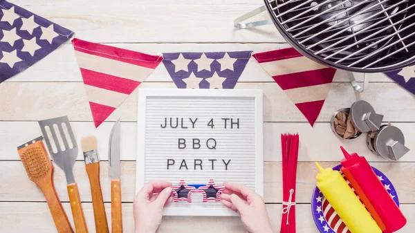 stock image July 4th BBQ Party sign on memo board with July 4th decorations.