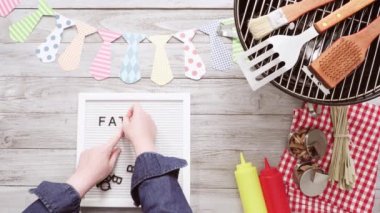 Babalar günü barbekü partisi beyaz faturası kurulu pişirme araçları ile oturum.