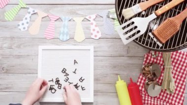 Babalar günü barbekü partisi beyaz faturası kurulu pişirme araçları ile oturum.