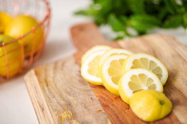 Ahşap kesme tahtası üzerinde organik limon dilimli.