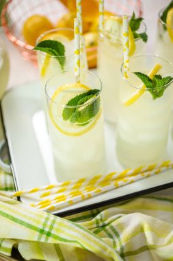 Taze limon ve nane ile kağıt saman cam bir dilim ile geleneksel limonata.