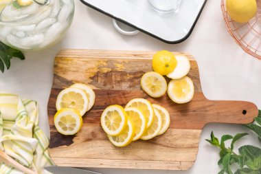 Ahşap kesme tahtası üzerinde organik limon dilimli.