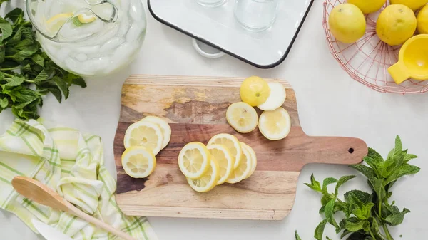 Ahşap kesme tahtası üzerinde organik limon Dilimleme.