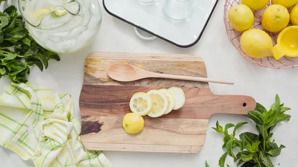 Ahşap kesme tahtası üzerinde organik limon Dilimleme.