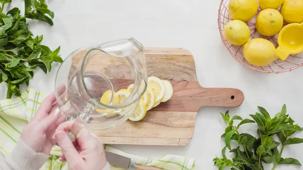 Ahşap kesme tahtası üzerinde organik limon Dilimleme.