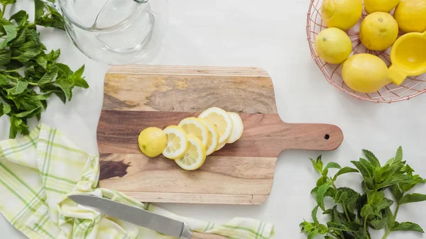 Ahşap kesme tahtası üzerinde organik limon Dilimleme.