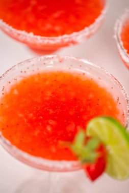 Taze çilek margarita kokteyl taze çilek ve kireç ile süslenmiş.