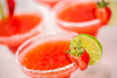 Taze çilek margarita kokteyl taze çilek ve kireç ile süslenmiş.