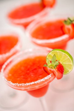 Taze çilek margarita kokteyl taze çilek ve kireç ile süslenmiş.