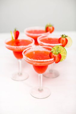 Taze çilek margarita kokteyl taze çilek ve kireç ile süslenmiş.