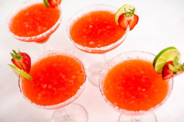 Taze çilek margarita kokteyl taze çilek ve kireç ile süslenmiş.