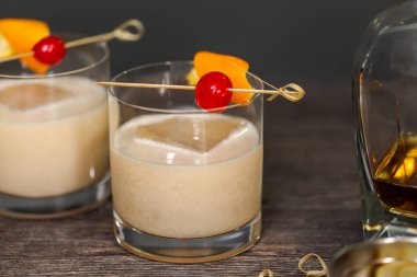 Viski kokteyli kokteyl portakal ve vişne ile süslenmiş.