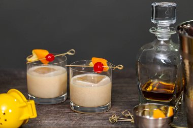 Viski kokteyli kokteyl portakal ve vişne ile süslenmiş.