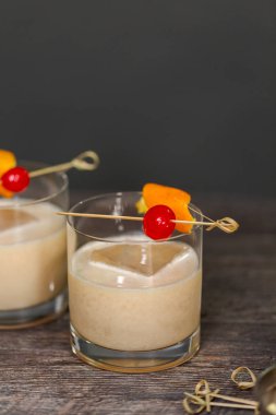 Viski kokteyli kokteyl portakal ve vişne ile süslenmiş.