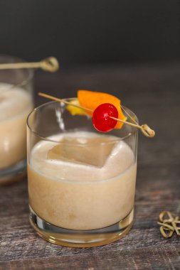 Viski kokteyli kokteyl portakal ve vişne ile süslenmiş.