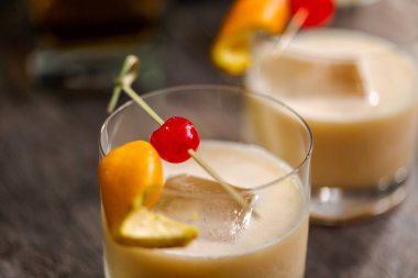 Viski kokteyli kokteyl portakal ve vişne ile süslenmiş.