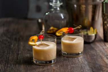 Viski kokteyli kokteyl portakal ve vişne ile süslenmiş.