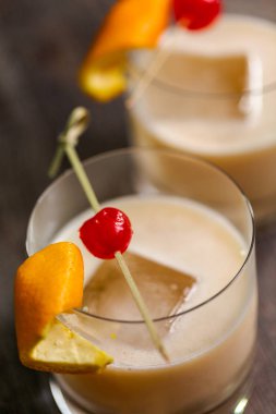 Viski kokteyli kokteyl portakal ve vişne ile süslenmiş.