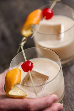 Viski kokteyli kokteyl portakal ve vişne ile süslenmiş.