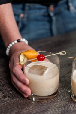 Viski kokteyli kokteyl portakal ve vişne ile süslenmiş.